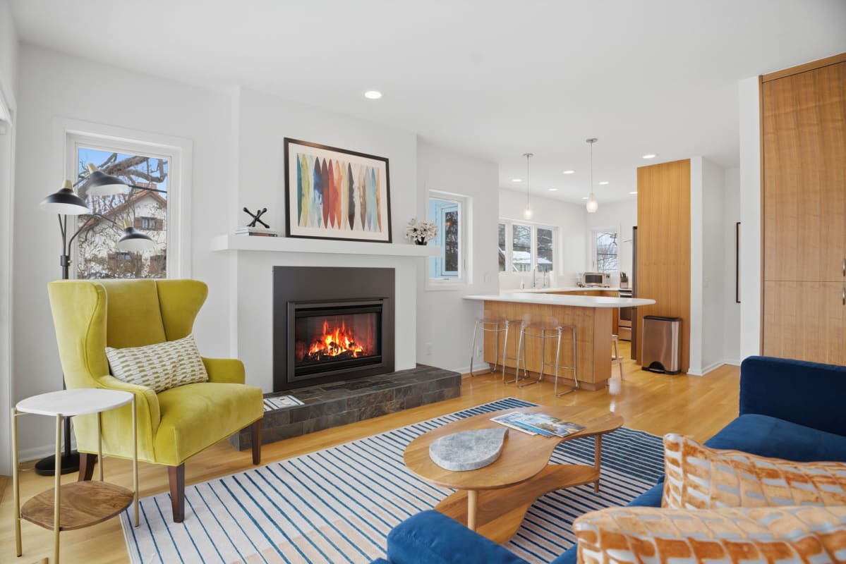 Relax by your cozy fireplace in this bright, modern family room where stylish furniture and warm wood tones create the perfect retreat.