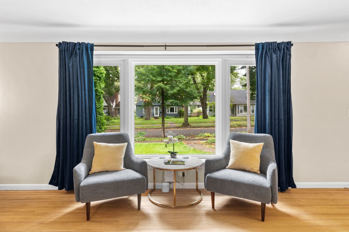 Your peaceful window seating overlooks a leafy residential neighborhood, with two cozy chairs perfect for morning coffee and quiet moments.