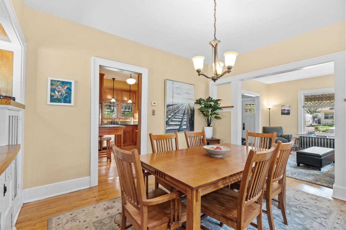 Gather around your warm wooden dining table for memorable meals and conversations in this inviting space with beautiful natural light.