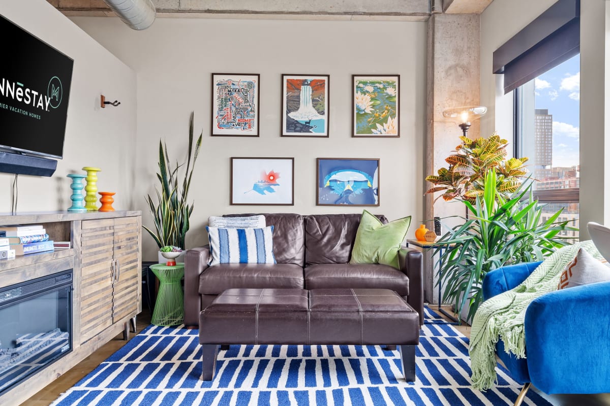 Settle into this vibrant living space where colorful art meets city views through expansive windows, perfect for your urban retreat.