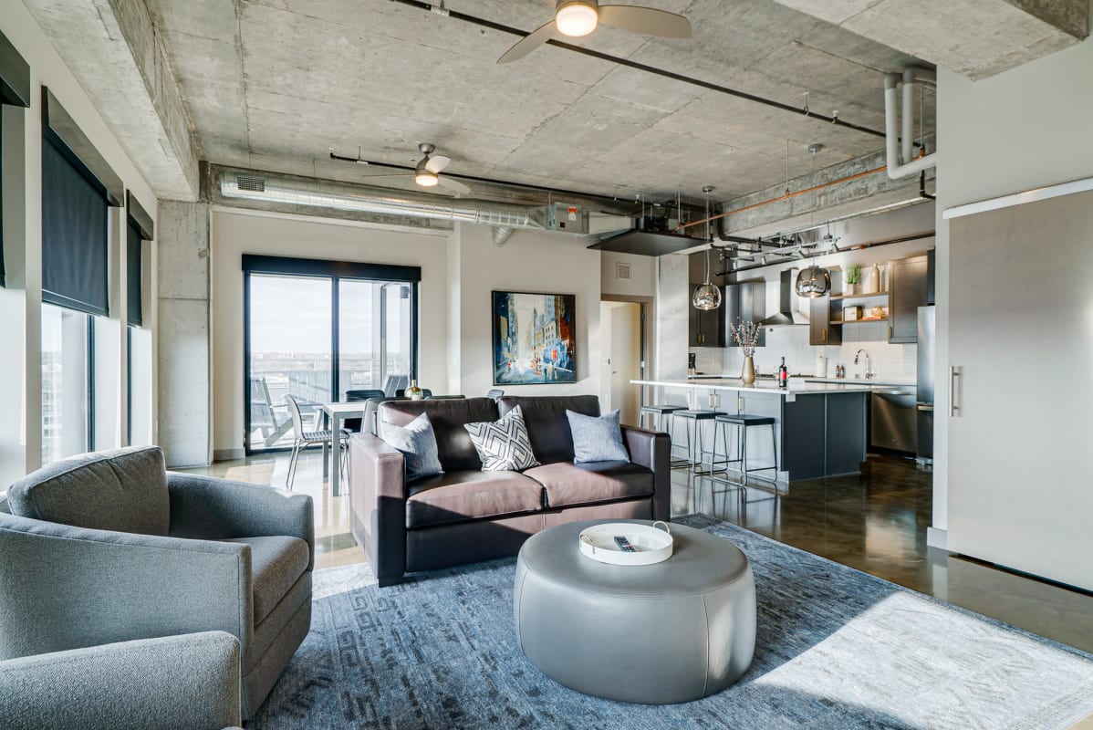 Your modern loft blends industrial chic with elegant comfort, featuring soaring concrete ceilings and floor-to-ceiling windows.