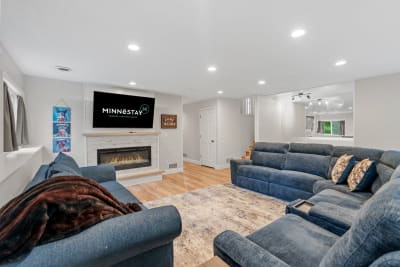 Modern living room with blue sectional sofa, fireplace, and TV.