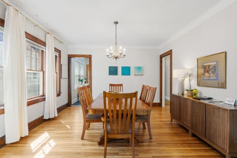 Cozy dining room featuring a wooden table, chairs, and warm decor.