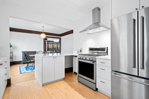 Modern kitchen with white cabinets and stainless steel appliances.