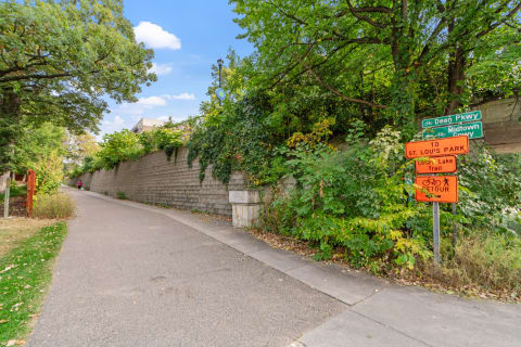 A winding urban trail with green surroundings and directional signs.