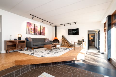 Stylish modern living room with gray sofa, abstract art, and a fireplace.