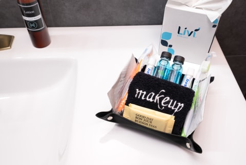 Organized grooming kit on bathroom countertop with personal care items like shampoo, lotion, and toothbrush.