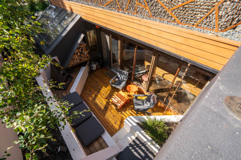 Outdoor area with wooden deck, lounge chairs, and greenery.