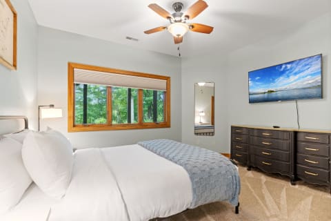 Cozy bedroom with a king-sized bed, decorative elements, and large windows.