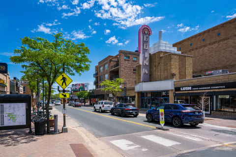 Downtown Edina street scene featuring a vintage cinema marquee and shops under a blue sky.