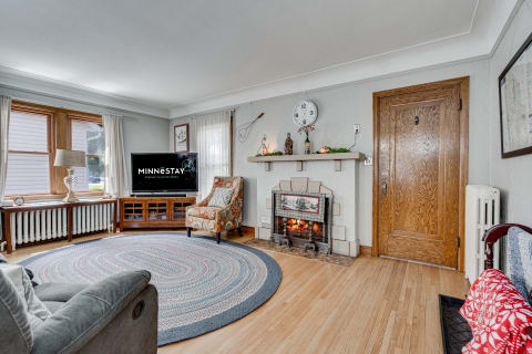 Cozy living room featuring a fireplace, a television, and a comfortable chair.
