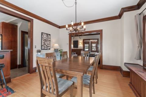 Dining room featuring a wooden table, chairs, and a unique chandelier.