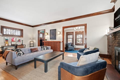 A cozy living room featuring a light gray sofa, navy blue chairs, a coffee table, and decorative art pieces.