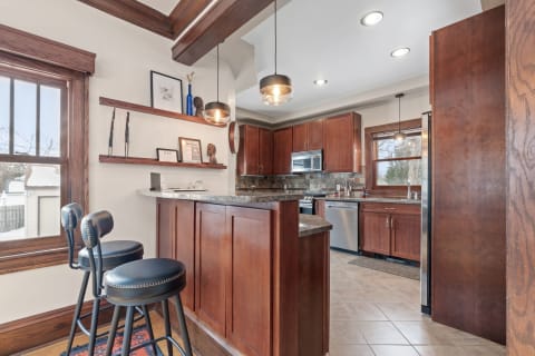 Contemporary kitchen with wooden cabinets and bar stools.