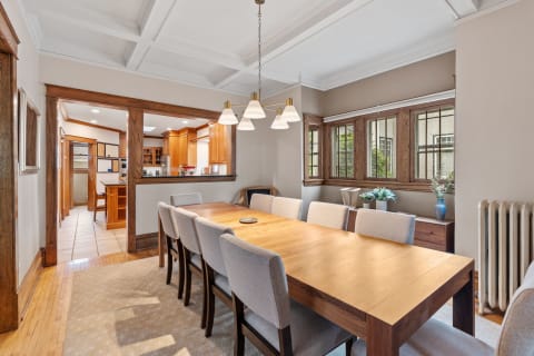 Spacious dining room featuring a wooden table, comfortable chairs, and large windows.