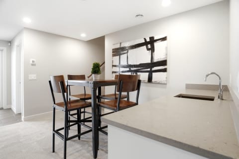 Modern kitchen nook featuring a bistro table and abstract wall art.