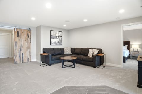 Cozy living room with a sectional sofa, wooden coffee table, and abstract wall art.