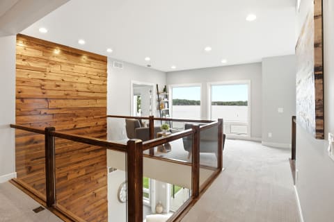Bright and airy upstairs loft featuring lake views, wood accents, and a cozy seating area.