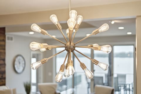 Mid-century modern chandelier with starburst design illuminating a contemporary living area.