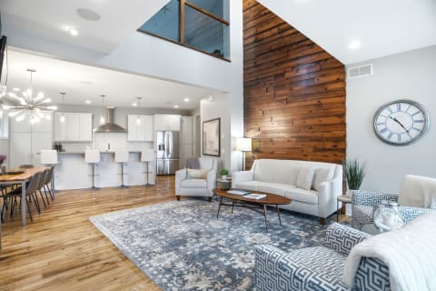Open-concept living area with soaring ceilings, wood accents, and a stylish chef's kitchen.