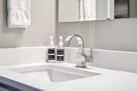Modern bathroom sink with a chrome faucet and elegant toiletries.