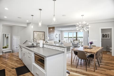 Open-concept kitchen and dining area with modern furnishings and lake views.