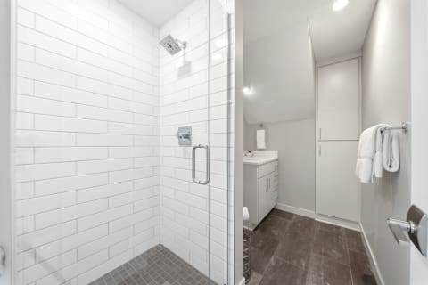Modern bathroom with subway-tile shower, gray floor, and minimalist vanity.