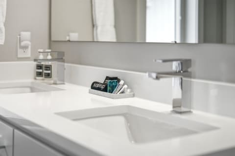 Modern bathroom with white countertop, chrome faucet, and organized beauty products.