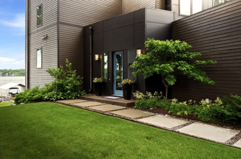 Modern home entrance with blue door and landscaped path