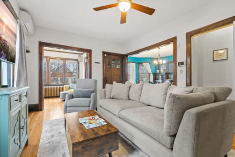 A modern living room featuring a gray sofa and a large window.