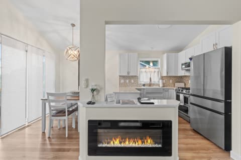 Modern kitchen with white cabinets, stainless steel appliances, and a cozy dining area.