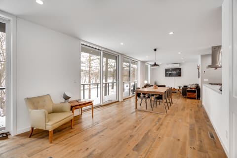 Interior view of a modern living space with a dining area and sliding glass doors.