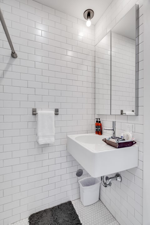 Contemporary bathroom with white subway tiles and a modern sink.