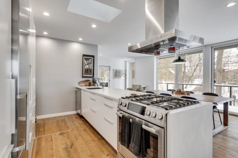 A contemporary kitchen with a large island, stainless steel appliances, and ample natural light from large windows.