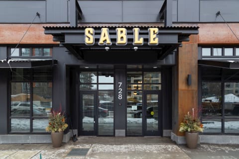 Entrance of the SABLE building showcasing industrial design with winter planters.