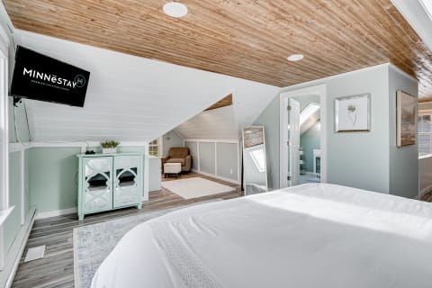 Interior view of a cozy loft bedroom featuring a bed, television, and comfortable seating.