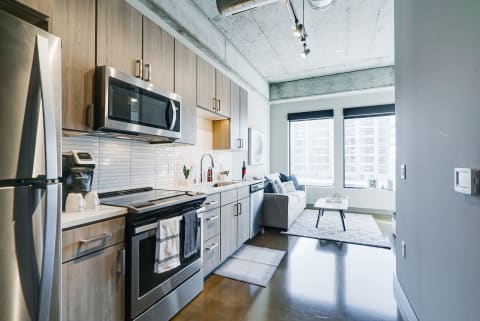 Contemporary kitchen with stainless steel appliances and a cozy living area.