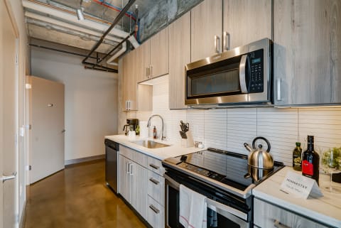 Modern kitchen with stainless steel appliances and light oak cabinets.