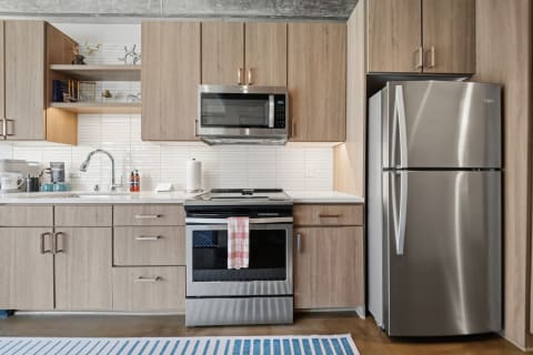 A contemporary kitchen featuring wood cabinets, stainless steel appliances, and ample counter space.