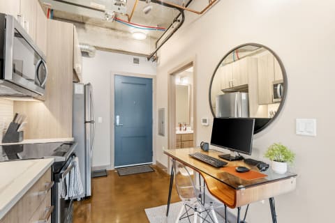 Interior view of a modern apartment with a workspace and kitchen.