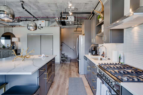 Modern kitchen with marble island and stainless steel appliances.