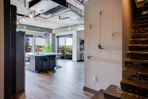 Modern interior with open kitchen, dining area, and climbing sculptures on the wall.