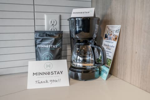 Coffee maker, coffee bag, and a thank-you card on a countertop.