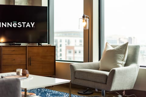 Cozy modern living room with an armchair, TV, and stylish lamp.