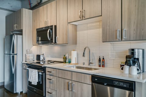 Contemporary kitchen featuring wood cabinets, black appliances, and a sleek design.