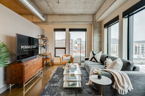 Modern living room featuring large windows, contemporary furniture, and city views.