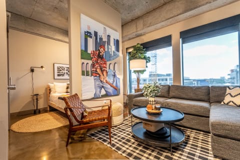 Contemporary living room featuring a sectional sofa, coffee table, and a large painting.