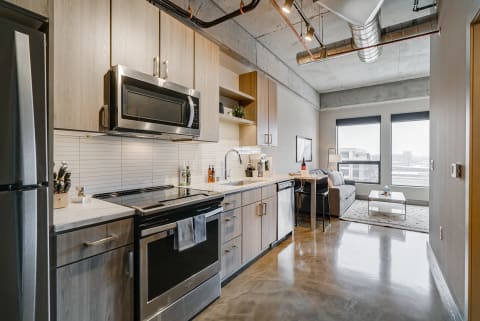 Contemporary kitchen with stainless steel appliances and a cozy living area.