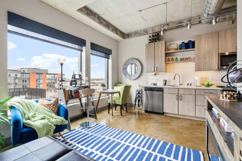 Modern apartment with large windows, stylish furniture, and a contemporary kitchen.