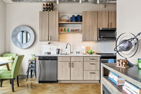 A contemporary kitchen layout with wooden cabinetry, stainless steel appliances, and decorative items.